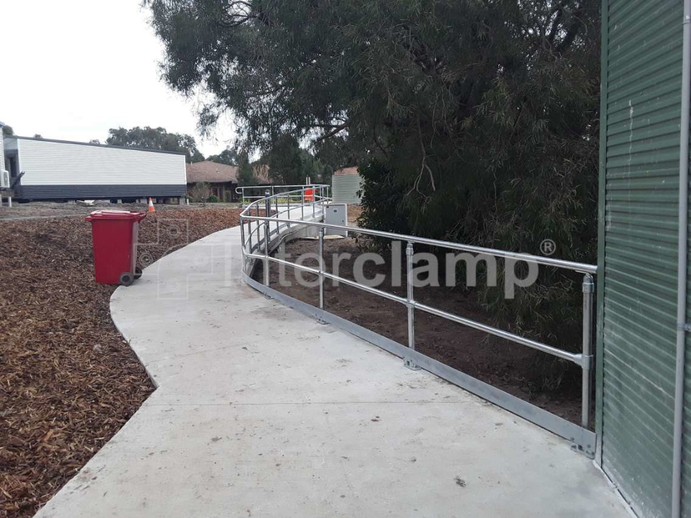 Interclamp DDA modular handrailing providing continuous support along a walkway, demonstrating its effectiveness in meeting the stringent safety requirements of AS 1428.1-2009.